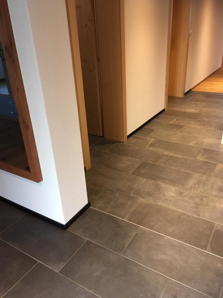 Nesslau: Mehrfamilienhaus. Keramik Bodenbeläge im Eingangsbereich, Gang, Bad und Küche. Feinsteinsteig 30 x 60 cm wild verlegt.