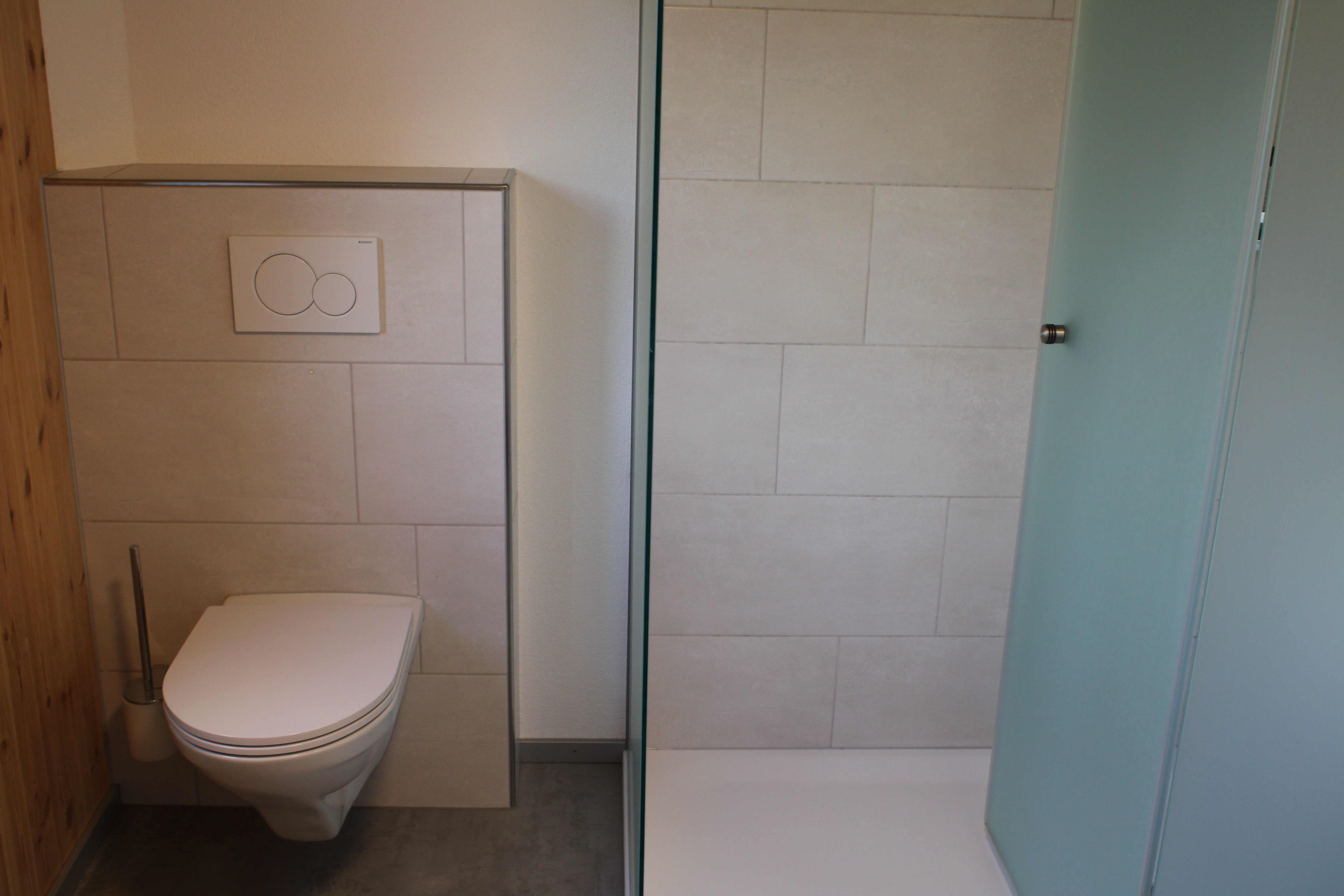 Kengelbach: Mehrfamilienhaus Totalsanierung. Plattenbeläge im Badezimmer, in der Dusche und im WC an den Wänden. Feinsteinzeug 30 x 60 cm