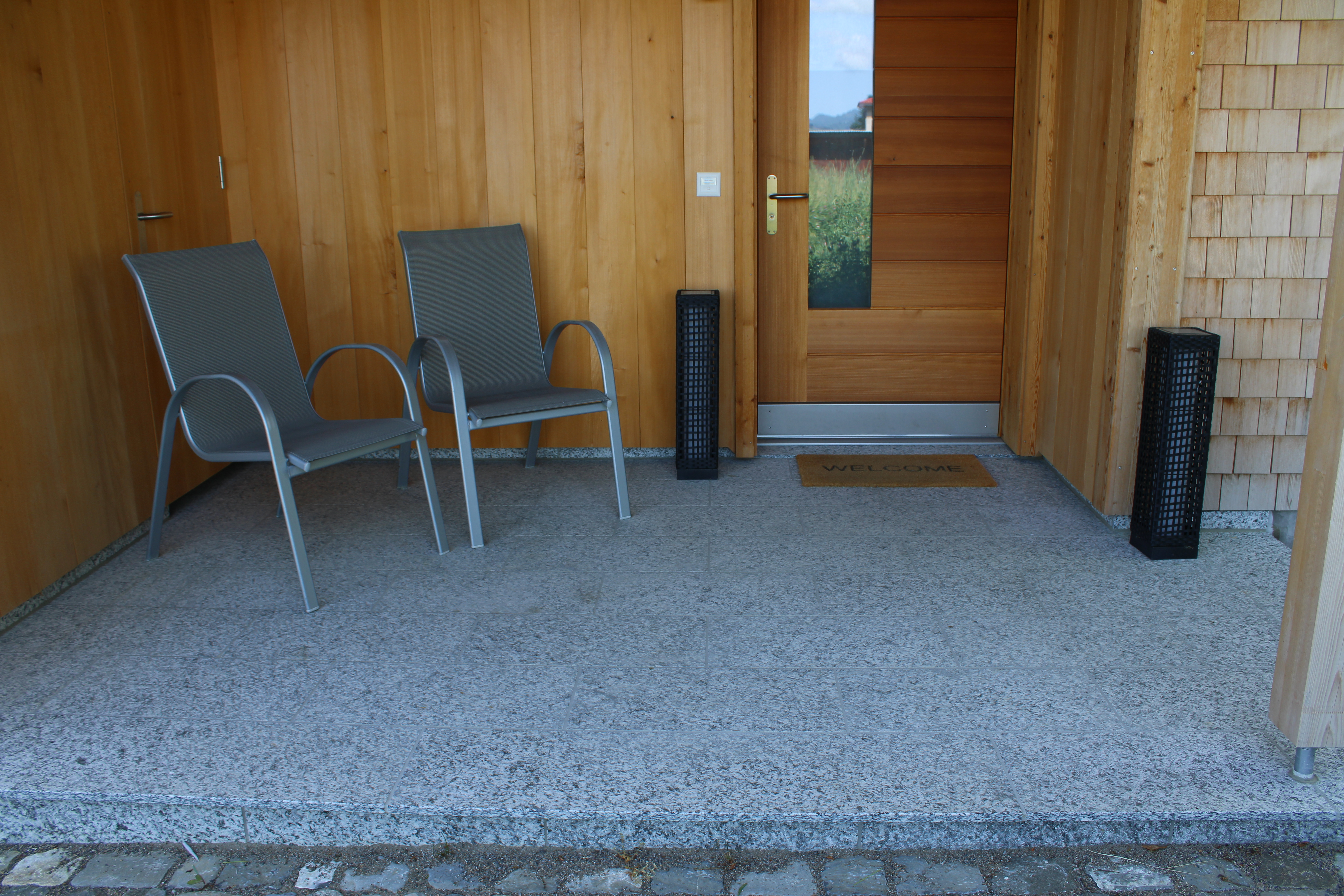 Ganterschwil: Neubau Eingangsbereich gedeckt. Naturstein Gneis aus der Schweiz. Verschieden grosse Plattenstücke mit Randfries.